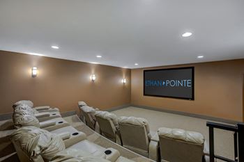 A row of white chairs are lined up in front of a screen that says ethan pointe.