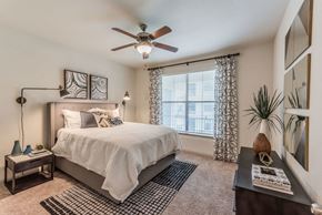 Houston apartment for rent - a bedroom with a large bed and a ceiling fan