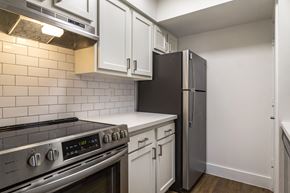Houston apartment for rent - kitchen with stainless appliances, white cabinets, white backsplash and white countertops