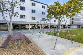 Key West apartment for rent - Swing Set in Front Of Picnic Tables Between Building Exteriors