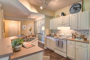 Austell apartment for rent - a kitchen with white cabinets and white appliances and a sink