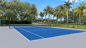 Boynton Beach apartment for rent - A tennis court surrounded by trees and a fence.