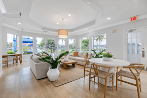 Boynton Beach apartment for rent - A living room with a white couch, a white coffee table, and a white vase with a plant in it.