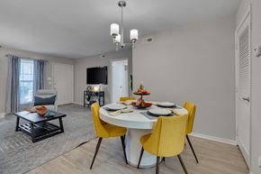 Raleigh apartment for rent - A dining room with a white table and yellow chairs.