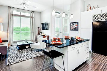 Denver apartment for rent - A kitchen with white cabinets and a black countertop.