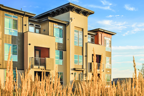 Denver apartment for rent - A modern building with a balcony and a red door.