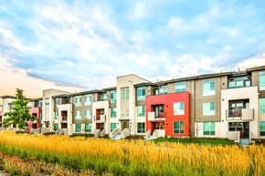 Denver apartment for rent - A row of modern apartment buildings with a grassy field in the foreground.