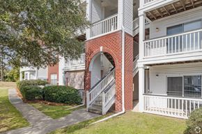 Hanahan apartment for rent - A red brick building with a white balcony.