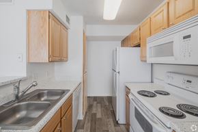 Hanahan apartment for rent - A kitchen with white appliances and wooden cabinets.