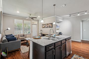 Mansfield apartment for rent - A kitchen with a grey couch and a counter with a sink.