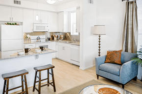 Denver apartment for rent - A kitchen with white cabinets and a blue couch.