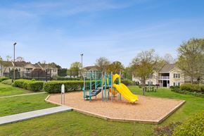 Warner Robins apartment for rent - Playground in bed of mulch and yellow slide with a sports court in the back