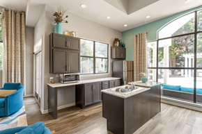 Charlotte apartment for rent - a kitchen with gray cabinets and a large window at Bridges at Mallard Creek Apartment Homes, Charlotte, NC
