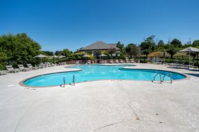 Seymour apartment for rent - A large outdoor swimming pool surrounded by lounge chairs and umbrellas.