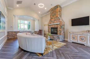 Frederick apartment for rent - A living room with a stone fireplace and a large white sofa.