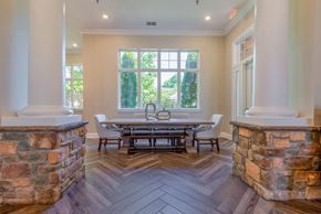 Frederick apartment for rent - A dining room with a table surrounded by chairs and a stone pillar.