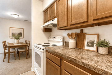 Waldorf apartment for rent - A kitchen with a white stove top oven and wooden cabinets.