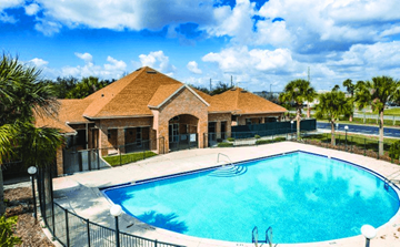 Kissimmee apartment for rent - A swimming pool in front of a house with a fence around it.