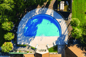 Kissimmee apartment for rent - An aerial view of a swimming pool surrounded by trees and a concrete patio.