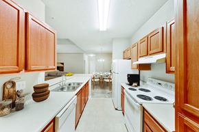 Kennesaw apartment for rent - A kitchen with wooden cabinets and white appliances.