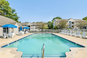 Columbia apartment for rent - A large swimming pool surrounded by chairs and umbrellas.