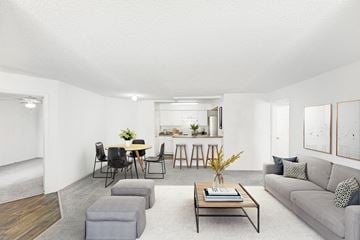 Orlando apartment for rent - A living room with a grey couch, a coffee table, and a dining table with chairs.