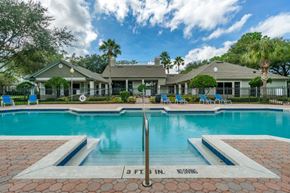 Orlando apartment for rent - Swimming pool lounge seating, sun deck, with clubhouse in the background