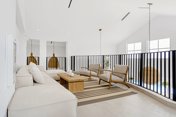 Dania Beach apartment for rent - A living room with a white couch and a black railing.