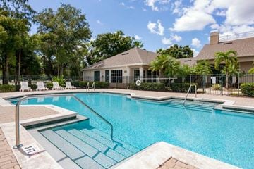 Fort Myers apartment for rent - A swimming pool with a slide and a house in the background.