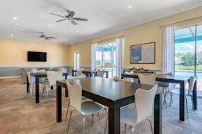 Naples apartment for rent - Clubhouse with Large Windows Black Tables with White Chairs Mounted TV and Ceiling Fans