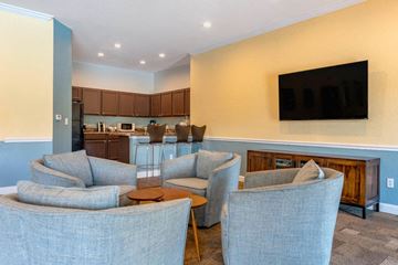Naples apartment for rent - A living room with grey chairs and a television on the wall.