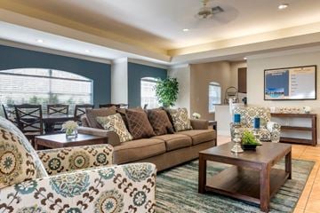 Jacksonville apartment for rent - A living room with a brown couch and a patterned armchair.