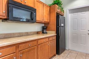 Jacksonville apartment for rent - Clubhouse kitchen with tile flooring and black appliances