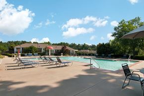 Dallas apartment for rent - Swimming Pool and Sun Deck with Lounge Chairs with Trees and Building Exteriors in the Background