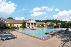 Dallas apartment for rent - Swimming Pool and Sun Deck with Lounge Chairs with Trees and Building Exteriors in the Background