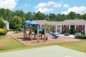 Dallas apartment for rent - Playground with wood chips in court yard between buildings.
