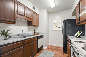 High Point apartment for rent - a kitchen with dark wood cabinets and white appliances at Eastchester Ridge Apartments, High Point, NC