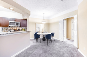 Charlotte apartment for rent - a dining area with a table and chairs and a kitchen in the background at Elan at Mallard Creek Apartment Homes, Charlotte, NC