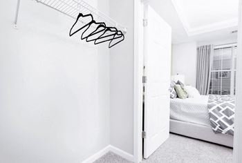 A white bedroom with a bed and a white wall.