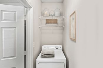 A white washing machine sits in a small laundry room.