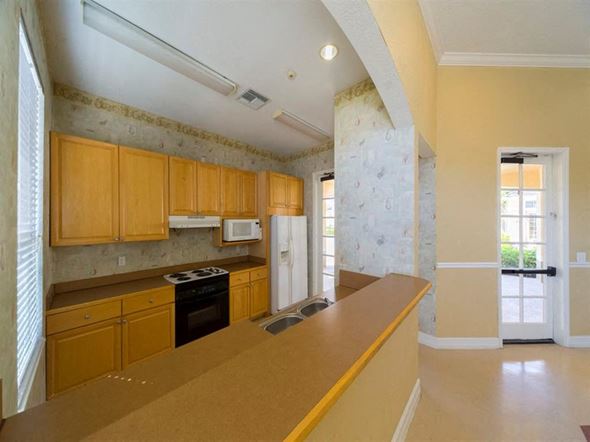 Naples apartment for rent - Community Center Kitchen with Light Wood Cabinets and Tan Counters