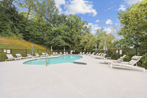 Knoxville apartment for rent - a resort style pool with white chairs and umbrellas