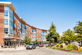 Denver apartment for rent - A large building with a parking lot in front of it.