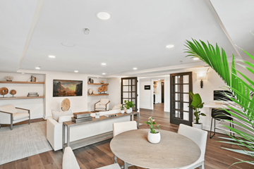Coral Gables apartment for rent - A modern living room with a white sofa set, a wooden coffee table, and a large painting on the wall.