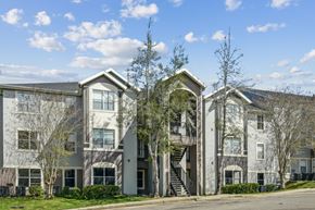 Tallahassee apartment for rent - A large apartment complex with a mix of grey and white buildings.