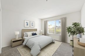 Kissimmee apartment for rent - a bedroom with a large window and a bed with a striped comforter