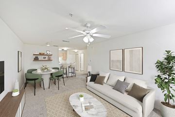 Kissimmee apartment for rent - A living room with a white couch, a coffee table, and a dining table with chairs.