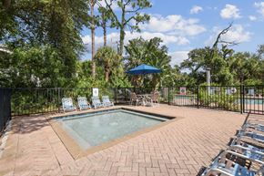 North Port apartment for rent - A pool surrounded by chairs and trees.