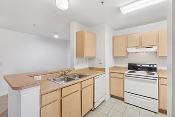North Port apartment for rent - A kitchen with wooden cabinets and white appliances.