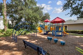 North Port apartment for rent - A playground with a red canopy and blue and yellow play equipment.